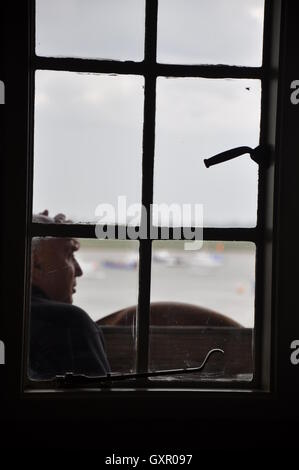Mann durch Fenster denken Stockfoto