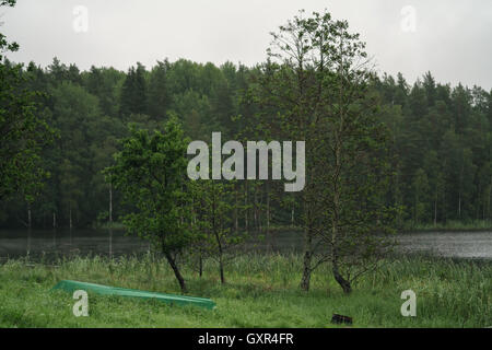 Boot auf dem Kopf stehend in der Nähe von See in dunstigen Sommermorgen Stockfoto