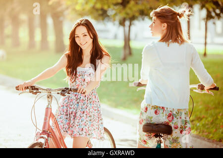 Die beiden jungen Mädchen mit Fahrrädern im park Stockfoto