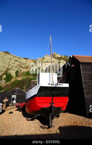 Angelboot/Fischerboot und historischen schwarz aus Holz Netto Geschäfte unter Osthügel-Klippe, Hastings, East Sussex, England Stockfoto