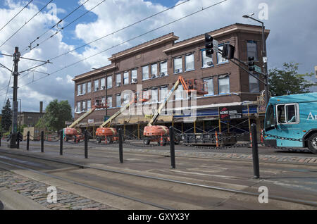 Rehabbing Sicherheit Gebäude University Ave, drei identische Cherry Pickers in der gleichen Position St.Paul Minnesota MN USA Stockfoto