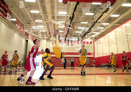 Defensive Basketball-Spieler springt in die Luft, die Aufnahme zu blockieren versucht. White Bear Lake, Minnesota MN USA North High School Stockfoto