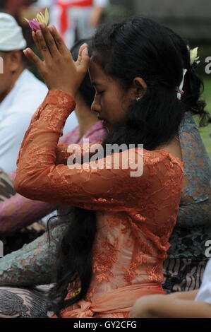 Balinesisches Mädchen, das während Galungan, Ubud, Bali, Indonesien, mit gefalteten Händen betet. Quelle: Kraig lieb Stockfoto