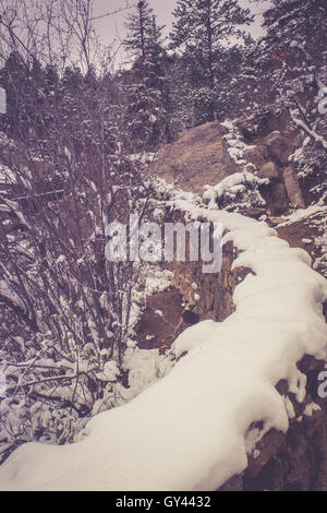 Steinmauer unter Schnee Stockfoto