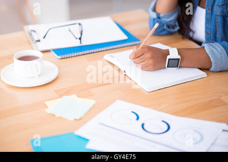 Schöne Frau sich Notizen macht. Stockfoto