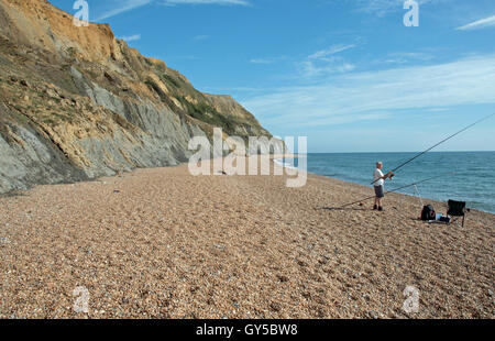 Ein einsamer See Fischer genießt die Ruhe an einem ruhigen Strand am Down Cliff, einladendsten, Dorset. Stockfoto