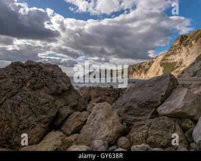 Landschaft, die felsige Küste der Mann O'War Strand an einem feinen Sommertag mit Durdle Door Landzunge im Hintergrund darstellen. Stockfoto