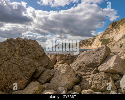 Landschaft, die felsige Küste der Mann O'War Strand an einem feinen Sommertag mit Durdle Door Landzunge im Hintergrund darstellen. Stockfoto