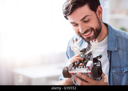 Fröhliche Menschen halten Roboter Stockfoto