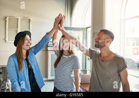 Glücklich begeisterte Geschäftspartner dabei eine hohe Fives Geste, wie sie einen Erfolg im Büro, trendige junge moderne g feiern Stockfoto