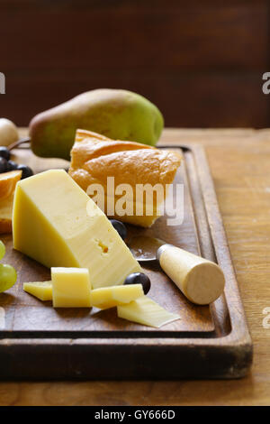 Käse vom Brett mit Trauben, Birnen und baguette Stockfoto