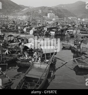 Die 1950er Jahre, historisch, ein Blick aus dieser Zeit auf das schwimmende Dorf in Aberdeen, Hongkong, auf Hong Kong Island, traditionell ein Zufluchtsort für die lokalen Fischer. Historisch gesehen lebten viele von ihnen auf ihren Fischerbooten, die als Dschunken bekannt sind, und wurden zu den „Menschen, die auf dem Wasser leben“. Die Bewohner des Hongkonger Bootes lebten in den 1960er und 1970er Jahren im schwimmenden Dorf Aberdeen weiter. Stockfoto