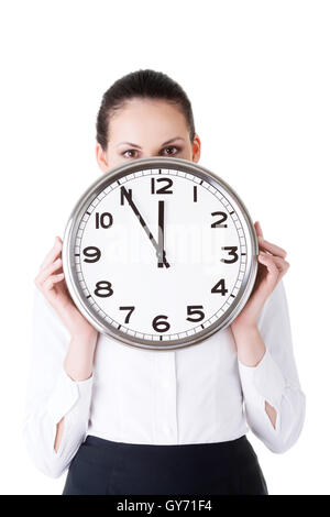 Business-Frau hält eine Uhr vor ihr Gesicht. Stockfoto