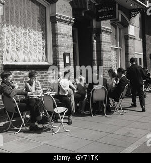 1950s, historisch, Menschen sitzen vor einem Watneys Pub, The Rutland Arms on the Lower Mall, London, W6, ein gepflasterter Durchgang neben der Themse, Chiswick, in der Nähe von Hammersmith, West London, England, VEREINIGTES KÖNIGREICH. Stockfoto