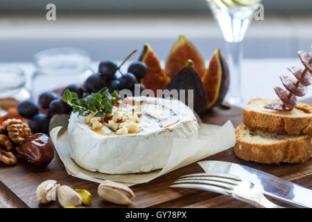Gebackener Camembert Käse mit Feigen, Honig, Trauben und Nüssen. Ansicht von oben Stockfoto