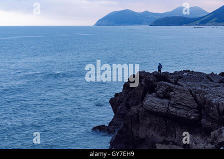 Ein Fischer mit ihren Ruten auf den Felsen, Meeresboden, Küste in Nordspanien Kantabrien Stockfoto