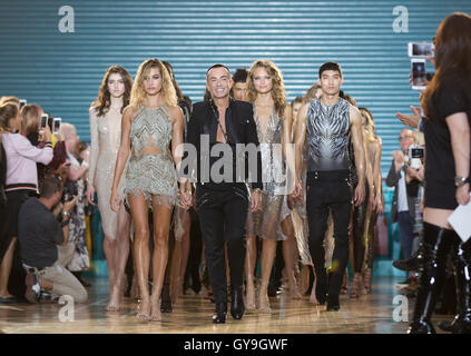 Designer Julien Macdonald Spaziergänge über den Laufsteg durch die Hand des American model Hayley Baldwin seine Frühjahr / Sommer 2017 London Fashionweek Show bei Seymour Leisure Centre, London. Stockfoto