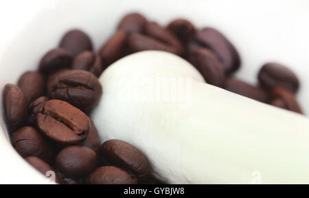 Kaffeebohnen in einem Mörser mit Stößel zerkleinern Stockfoto