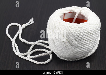 weiße Roll Seil auf schwarzen Holzboden. Stockfoto