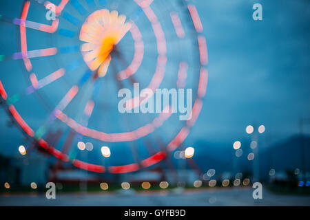 Abstrakte Motion Blur Bild hell bunt beleuchteten Riesenrad In Stadt Vergnügungspark auf schwarz blau Abend Himmel Bokeh Stockfoto