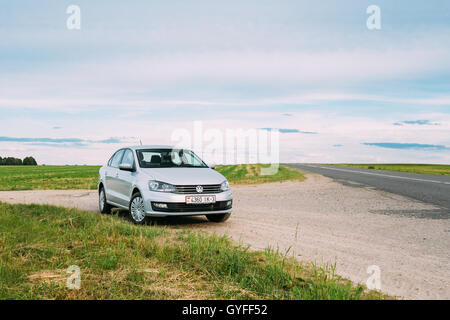 Gomel, Weißrussland - 13. Juni 2016: Volkswagen Polo Parkplätze am Straßenrand der Landstraße auf einem Hintergrund von Frühlingsgrün Felder Stockfoto