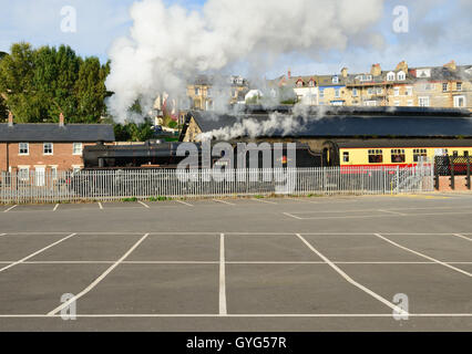 Dampfzug auf der North Yorkshire Moors Railway, Whitby neben einem leeren Parkplatz zu verlassen. Stockfoto