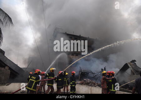 Feuerwehrleute arbeiten, um ein Feuer in einer Tampaco Verpackung Fabrik in Tongi Industriegebiet außerhalb Dhaka, Bangladesh. Stockfoto