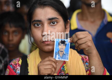 Verwandter von Fabrikarbeiterin aus Bangladesch hält sein Bild in einem Gebäude, wo ihre Körper nach einer Explosion gebracht wurden Stockfoto