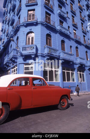 Kuba, Havanna, rotes Auto übergibt blaues Gebäude Stockfoto