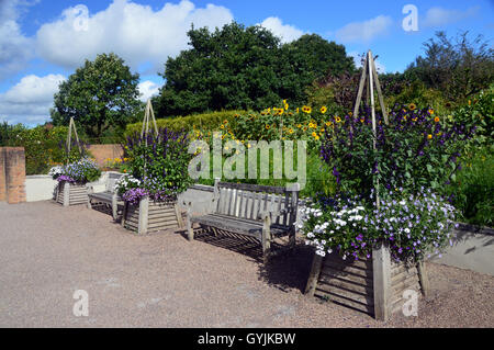 Eine Darstellung der hölzerne Blume Behältnisse und Bänke im Garten RHS Harlow Carr. Yorkshire, England, Vereinigtes Königreich. Stockfoto