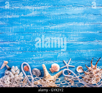 Muscheln mit Fischernetz auf blauem Hintergrund Stockfoto