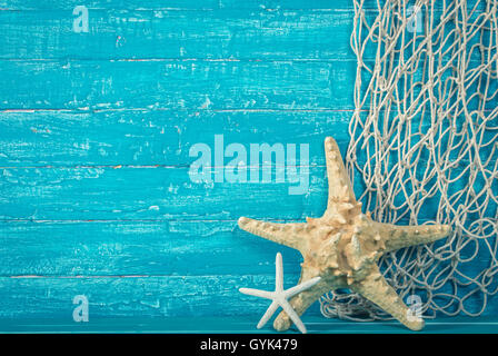 Seesterne und Fischernetz auf blau Stockfoto