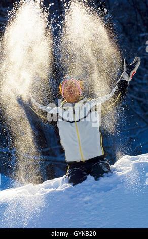 Frau werfen Schnee bis in die Luft, Frankreich Stockfoto