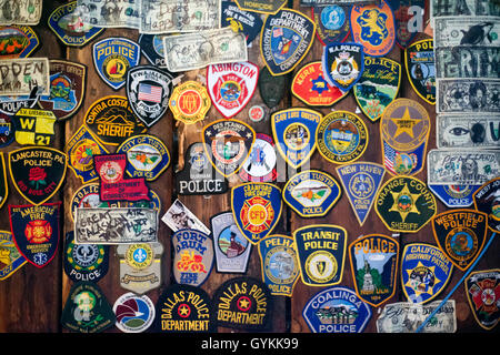 Verschiedene Embleme der Sicherheitskräfte und amerikanische Feuerwehr. In der Innenstadt. Straßen von Juneau. S Franklin Street. Red Dog Saloon. Stockfoto