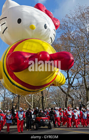 Ein Team von Handlern begleitet den Hello Kitty Ballon, Central Park West in die Macy's Thanksgiving Day Parade in New York City. Stockfoto