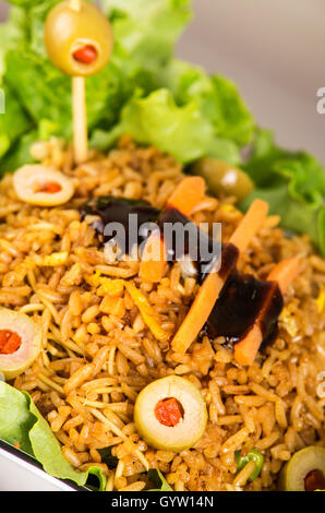 Closeup klassische Präsentation Salat, Reis und Oliven in künstlerischen weißen Teller mit abstrakten Hintergrund Stockfoto