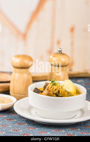 Edel Portion Kartoffel Suppe mit Fleisch und Gemüse, serviert in weißen Schalen auf Tisch, Blaue Tischdecke, Salz Pfefferstreuer, gemütliche Restaurant Hintergrund Stockfoto