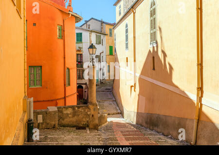 Schmale Straße zwischen bunten Häusern in der Altstadt von Menton, Frankreich. Stockfoto