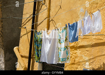 Detail-Wäsche in der Sonne auf gelbem Hintergrund Wand hängen Stockfoto