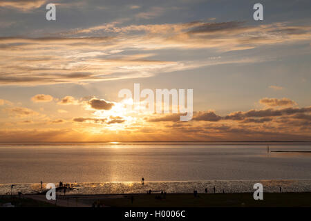 Sonnenuntergang über der Nordsee, Wanderer gegen das Licht, Norddeich, Ostfriesland, Niedersachsen, Deutschland Stockfoto