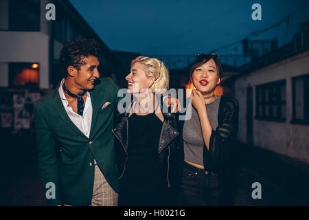 Heterogene Gruppe von Freunden auf der Straße in der Nacht laufen. Gemischtrassig junger Mann und Frauen freien Abend genießen. Stockfoto
