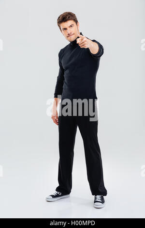 Wütend hübscher junger Mann stehen und auf Sie gerichtet Stockfoto