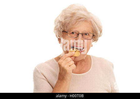 Ältere Frau Essen einen Cookie isoliert auf weißem Hintergrund Stockfoto