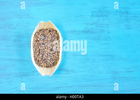 Samen von einem Mariendistel (Silybum Marianum) in einer Holzschale auf rustikalen Tisch, Raum für Text, Ansicht von oben. Stockfoto