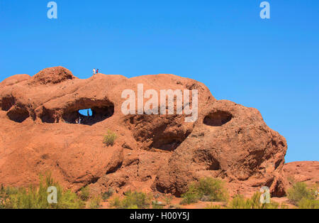 Hole-in-the-Rock, Höhle aus rotem Sandstein mit Klettern Touristen, USA, Arizona, Papago Park, Phoenix Stockfoto