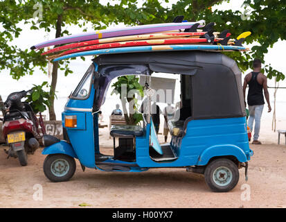 WELIGAMA, SRI LANKA - 7. März 2014: blaue Tuk Tuk Fahrzeug den Transport von Surfbrettern auf dem Dach. Tourismus und die Fischerei sind zwei wesentliche Stockfoto