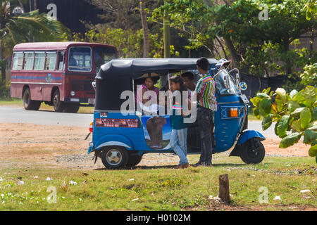 WELIGAMA, SRI LANKA - 7. März 2014: Menschen vor Ort in Tuk-Tuk-Fahrzeug. Tourismus und die Fischerei sind zwei Hauptgeschäft in dieser Stadt. Stockfoto