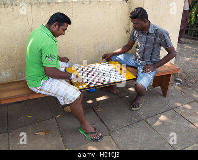 HIKKADUWA, SRI LANKA - 22. Februar 2014: Einheimische Männer spielen Dame auf der Straße. Checkers ist sehr beliebte Brettspiel auch bekannt als D Stockfoto