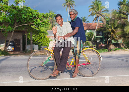 HIKKADUWA, SRI LANKA - 24. Februar 2014: zwei Männer auf bunte Fahrrad. Radfahren ist der Haupttransport für die traditi Stockfoto