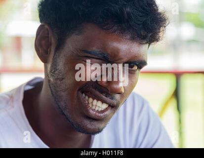 WELIGAMA, SRI LANKA - 7. März 2014: Porträt des jungen Mann augenzwinkernd für Kamera. Menschen vor Ort in Sri Lanka sind sehr freundlich Stockfoto